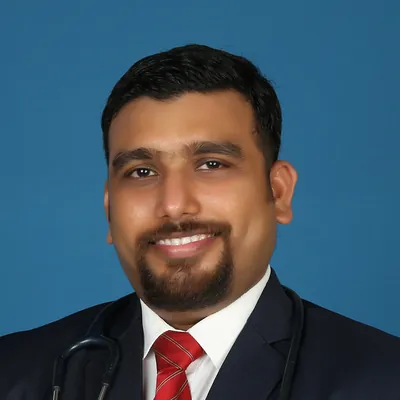 Portrait of Dr. S. R. Raveendran in a suit with a stethoscope